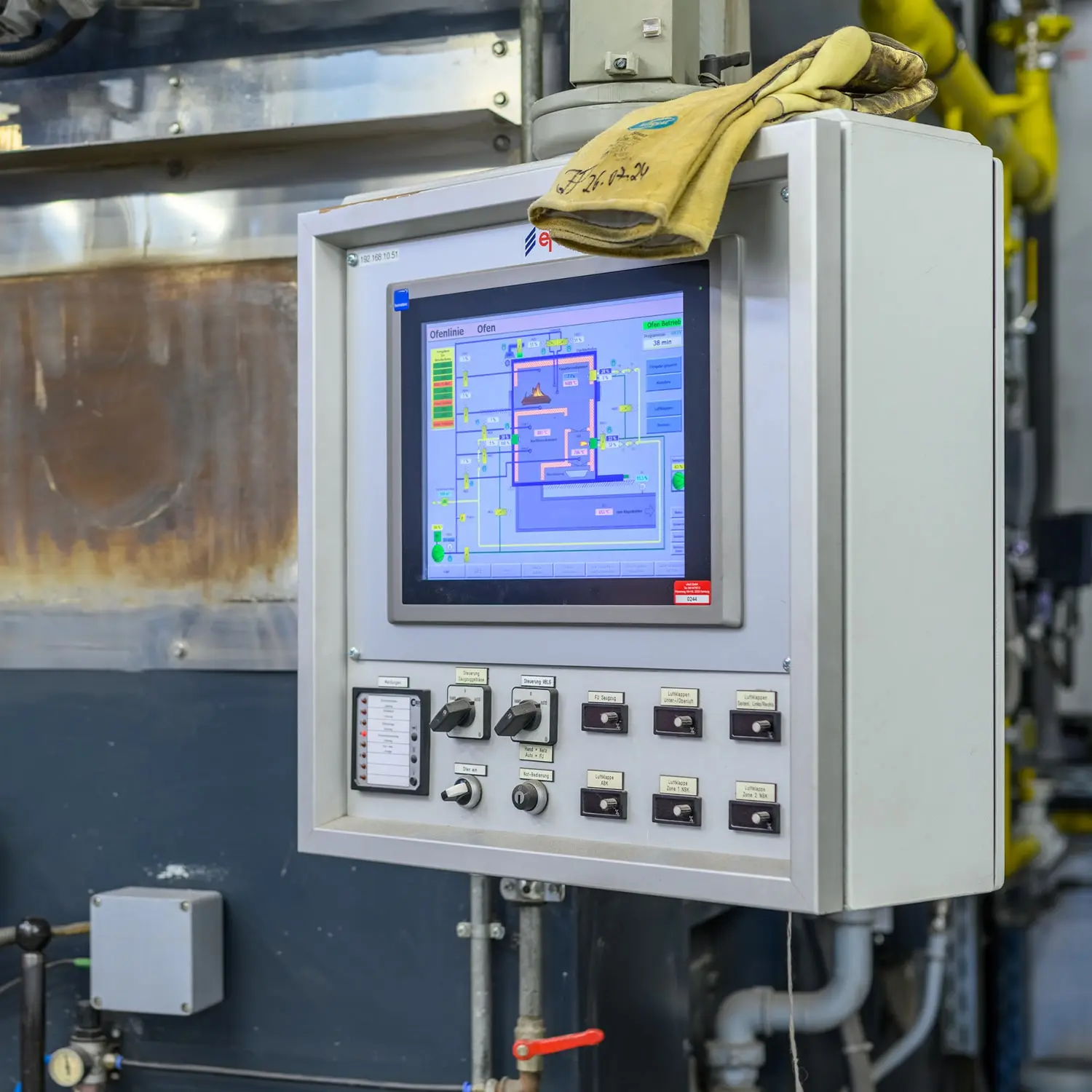 Industrielles Bedienfeld zur Ofensteuerung mit Prozessvisualisierung und Arbeitshandschuhen.