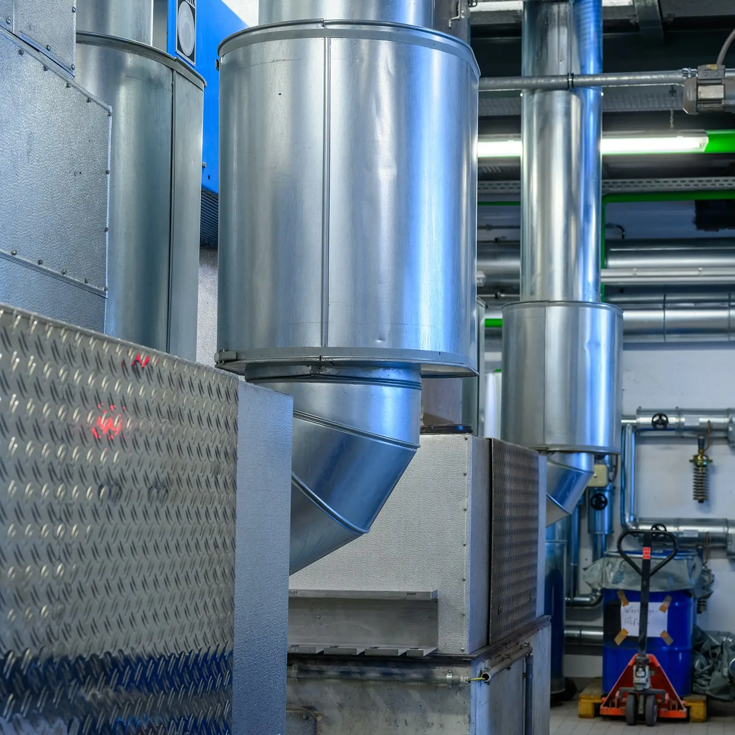 Industrielle Lüftungsanlage aus Metall in einem Technikraum.